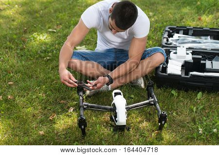 Man Tightening Drone Propeller In Nature