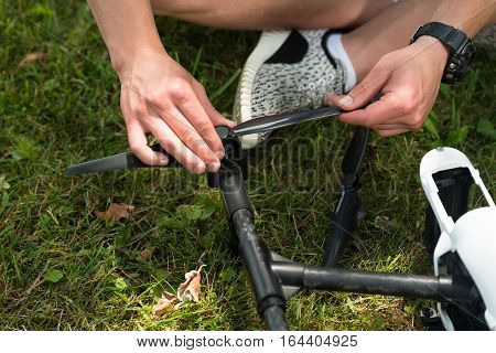 Man Tightening Propeller On Drone In Nature