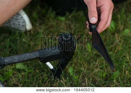 Man Tightening Propeller On Drone In Nature