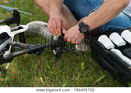 Man Tightening Propeller On Drone In Nature