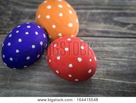 Easter egg colored polka dots lie on wooden background