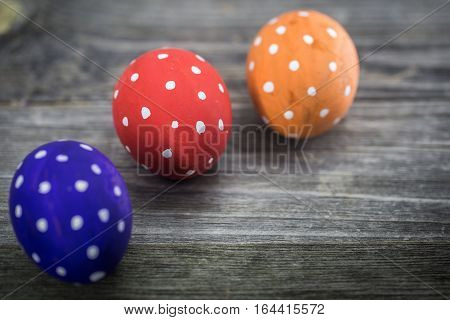 Easter egg colored polka dots lie on wooden background