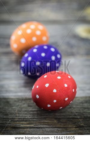 Easter egg colored polka dots lie on wooden background