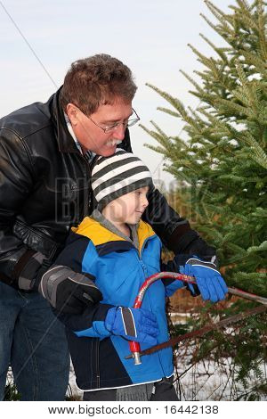 Far och son skära ner en julgran