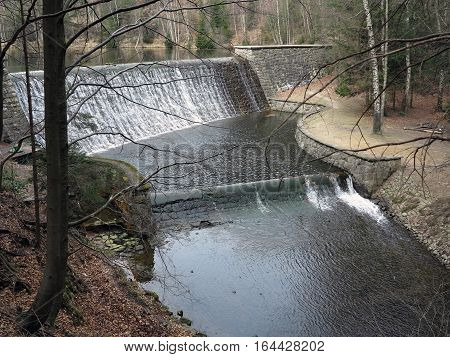 Cascade of water to spillway of the dam in the forest