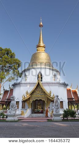 Buddhist Monk Working With Broom Sweeps Floor In Front Of Golden Pagoda