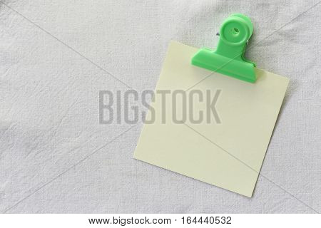 yellow of note paper placed on White fabric backgroundDesign ideas can be Entered your Message into the space as needed.