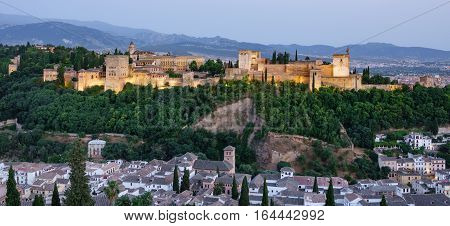 Closeup of Granada and the ancient arabic fortress of Alhambra at dusk with Sierra Nevada in the background. Spain.