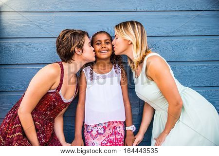 Lesbians mothers with adopted child - Happy homosexual family playing with her daughter