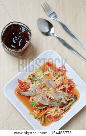 SOM TUMThai foods or papaya salad with fresh shrimp in spicy taste and is popular in thailand on wooden table background.
