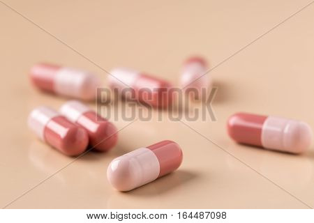 Heap of broun medicine capsules on beige background