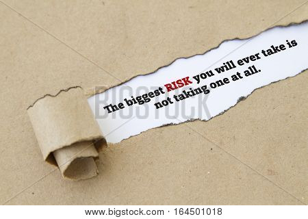 The biggest risk you will ever take is not taking one at all message written under torn paper.