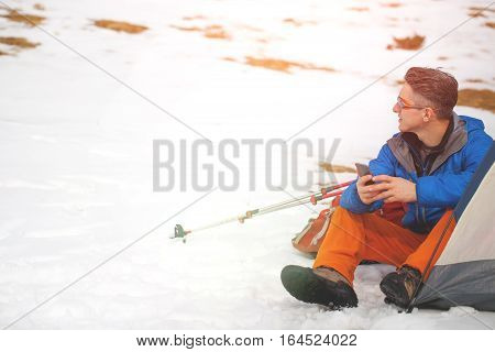 A Man Sits In A Tent In The Winter.