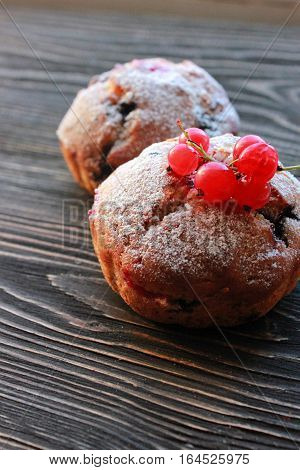 fresh muffins with berry on wooden background