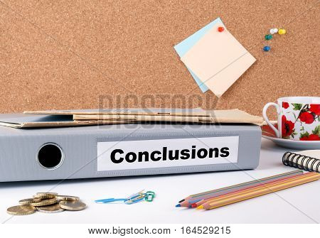 Conclusions. Folder, Coffee Mug, colored pencils on wooden office desk.