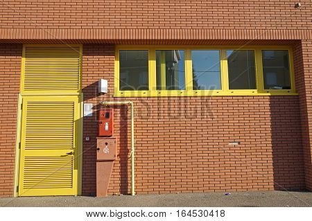 facade of brick industrial building with door and hidrant .