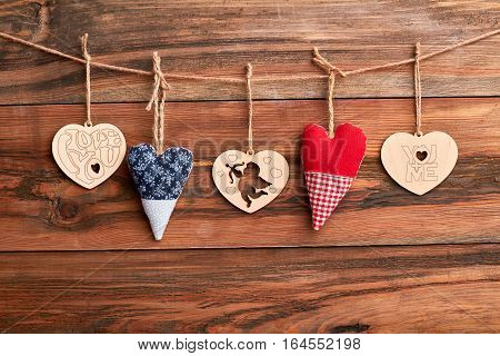 Hearts on rope. Hearts on brown wooden surface. Create positive and romantic mood.