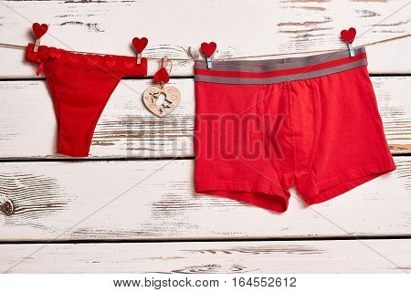 Red panties and boxer briefs. Underwear on rope with clothespins. Red color as love symbol.