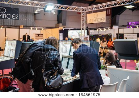 STRASBOURG FRANCE - JAN 8 2017: Young couple choosing wedding rigns with booths and people at Salon du Marriage the guide exhibition for bridal and formal wear industry