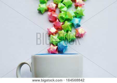 colorful star paper fling from coffee cup on white background