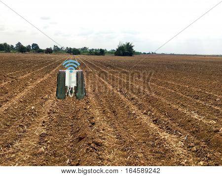 internet of things(industrial agriculture and smart farming concept)farmer use robot for keeping the data in the field by using the signal and the detector