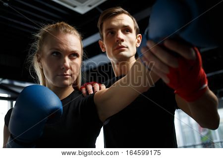 Training of young girl with coach in gym