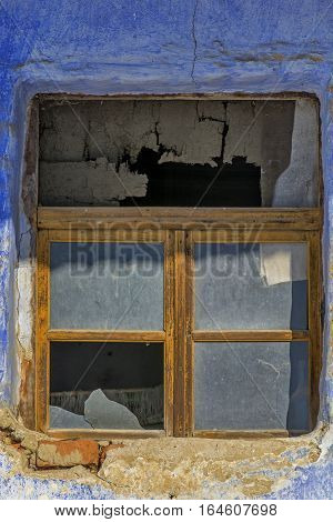 Close- up old window frame in a vintage bricks wall in a rural romanian house. Old wall with window detail of an old building in ruins.