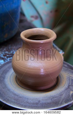 A clay pot on a pottery wheel, pottery craft, moulding the pot with your hands, sculpting hands