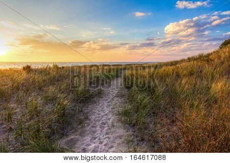A Walk In The Dunes. Sandy path winds along the shore of Lake Michigan with a sunset horizon and sand dunes as a backdrop. Muskegon, Michigan