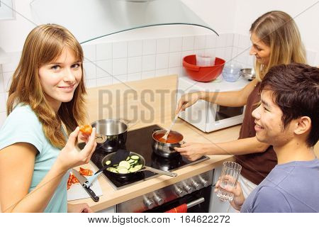 Group of friends cooking together at home.