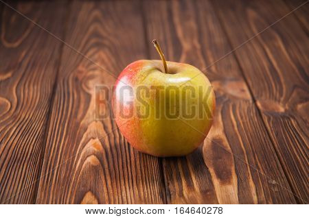 red and yellow apples on a wooden table