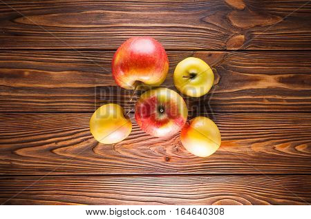 red and yellow apples on a wooden table