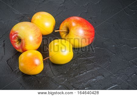 red and yellow apples on a black table