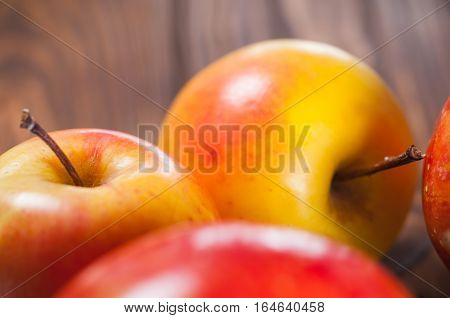 red and yellow apples on a wooden table