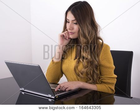 Girl sitting in home working with her laptop