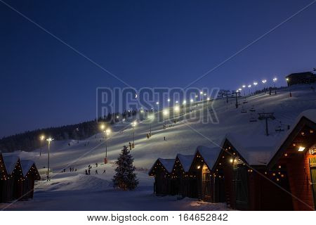 winter market village in Levi, Finland in the evenig on lightened ski cable way background