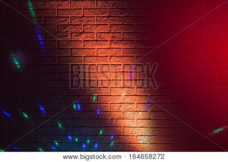 Textured brick wall lit by many colored lights