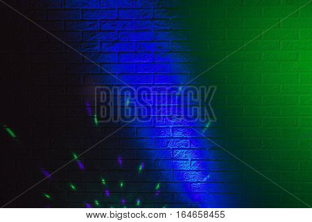 Textured brick wall lit by many colored lights