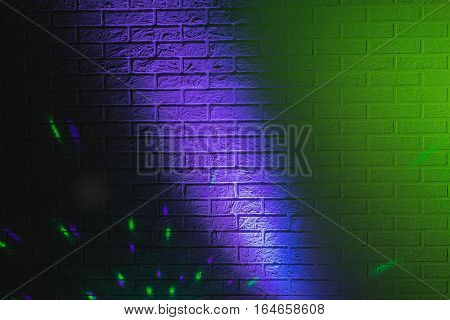 Textured brick wall lit by many colored lights