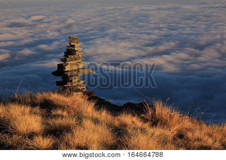 Autumn scene in the Annapurna Conservation Area Nepal. Cairn and sea of fog.