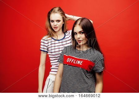 two best friends teenage girls together having fun, posing emotional on red background, besties happy smiling, lifestyle people concept close up