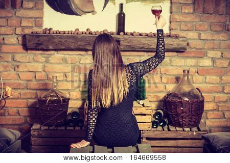 Woman Tasting Wine In Rural Cottage Interior