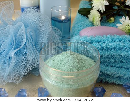 Spa essentials (salt, bast, blå flaske shampoo, sæbe, stearinlys og håndklæde med blomster)