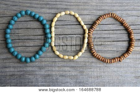 Colorful wooden bracelets on old wooden background.Handcrafted bangles.Handmade wooden bead bracelet.Selective focus.Copy space.