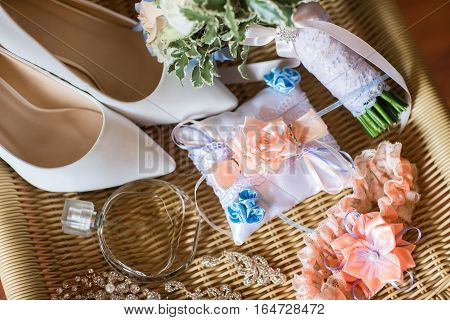 Wedding accessories: perfume bottle and a garter on table