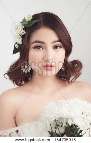 Beautiful asian woman bride on grey background. Closeup portraits with a professional makeup