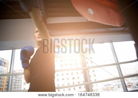 Young sportswoman boxing at gym in sports clothing