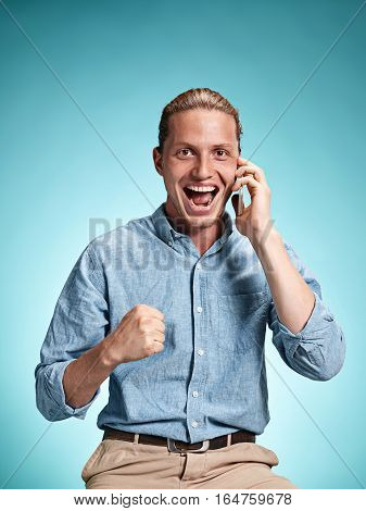 The Young Smiling Caucasian Man On Blue Background