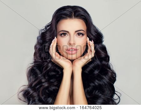 Spa Beauty and Skincare Concept. Spa Woman Fashion Model with Healthy Hair and Skin. Brunette with Natural Makeup Long Curly Hairstyle and Manicure