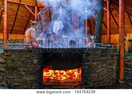 Lumshory Ukraine - January 10 2017: Tourists bathing in the cast iron vat with mineral water containing hydrogen sulphide. Water in cast iron vats heated to 40-45 degrees Celsius.